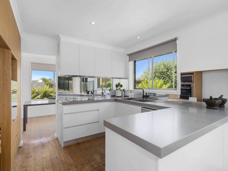 Ốp bếp đá nhân tạo Hàn Quốc màu ghi làm nên một điểm nhấn hút mắt trong không gian bếp màu trắng.